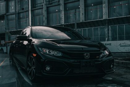 A black Honda Civic Si parked in front of a building under construction