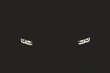a pair of silver cufflinks on a black background