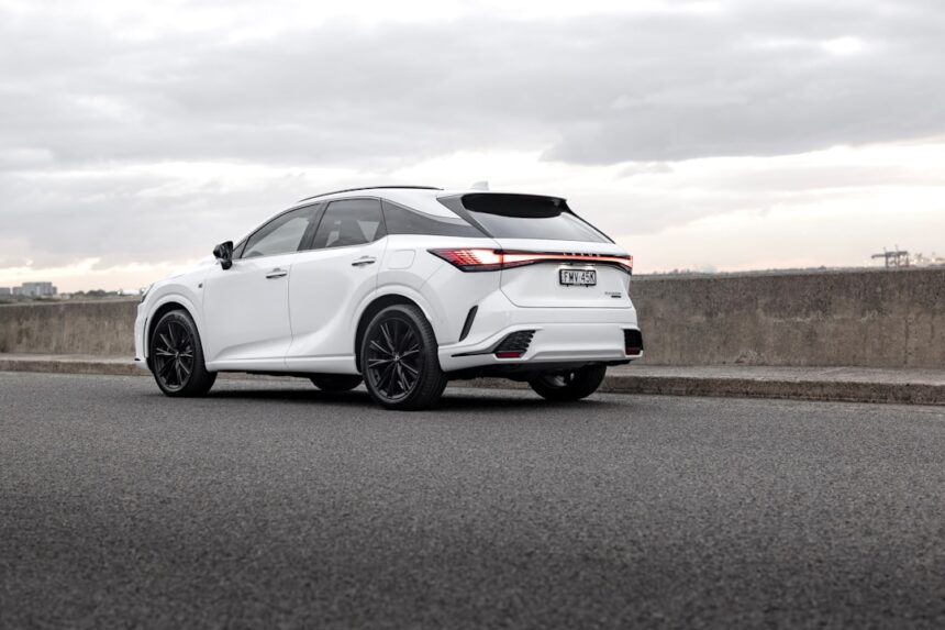 A white lexus suv is parked on the side of the road