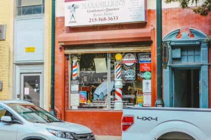 a white truck parked in front of a barber shop