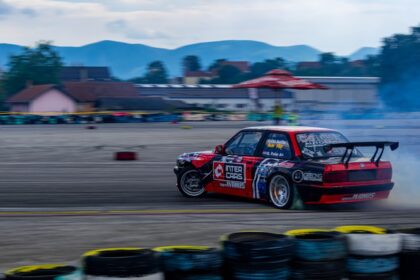 a car with smoke coming out of it driving on a track