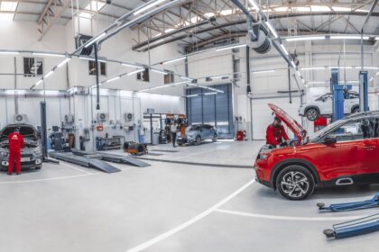 Mechanics working on cars in a bright, spacious automotive repair workshop