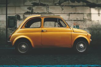a small yellow car parked in front of a building