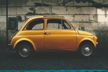 a small yellow car parked in front of a building