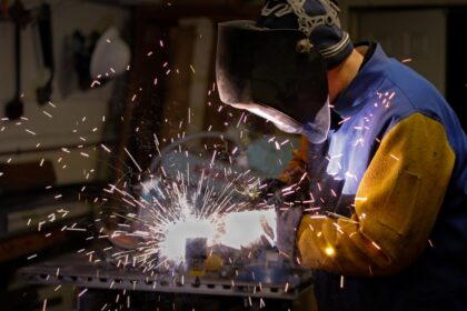 a man wearing a blue protective gear working on a machine