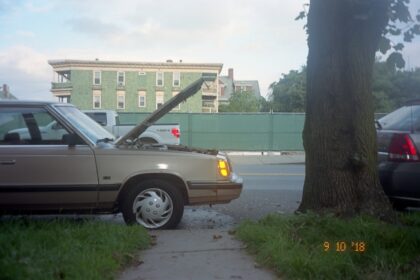 silver sedan parked on sidewalk during daytime