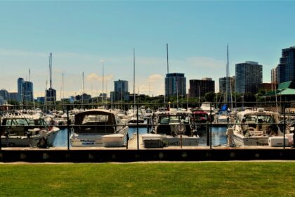a marina filled with lots of boats next to tall buildings