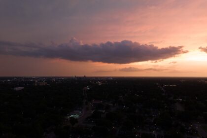 the sun is setting over a city in the distance