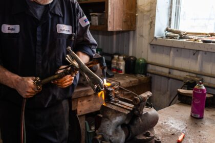man in black jacket holding black and yellow power tool