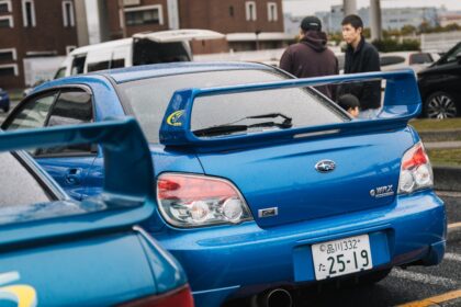 Two blue subaru wrx cars parked side by side