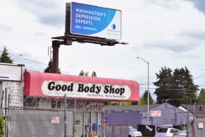 a billboard on the side of a building advertising a body shop