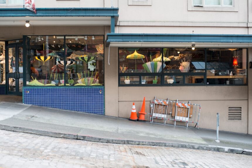 Storefront with plants, cones, and chairs on a sloping sidewalk