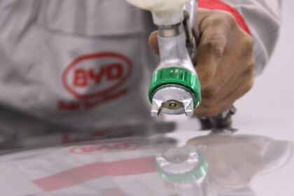 person holding green and white plastic bottle