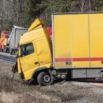 A yellow semi-truck is in a roadside accident