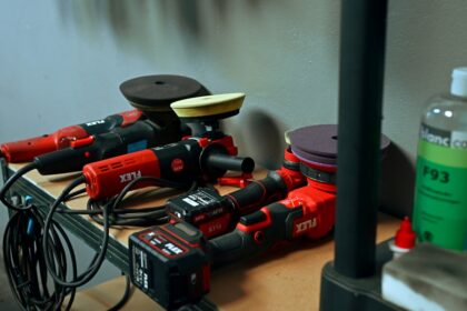 Several red car polishing tools on a shelf