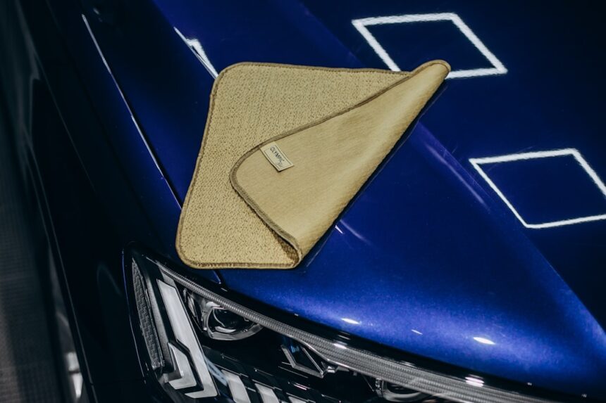 A microfiber cloth rests on a shiny blue car