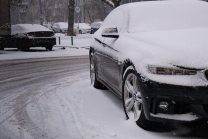 a car covered in snow on a snowy street