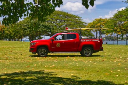 A red rescue truck is parked on the grass
