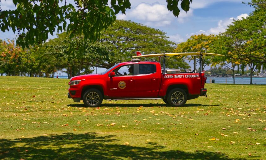 A red rescue truck is parked on the grass