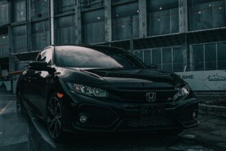 A black Honda Civic Si parked in front of a building under construction