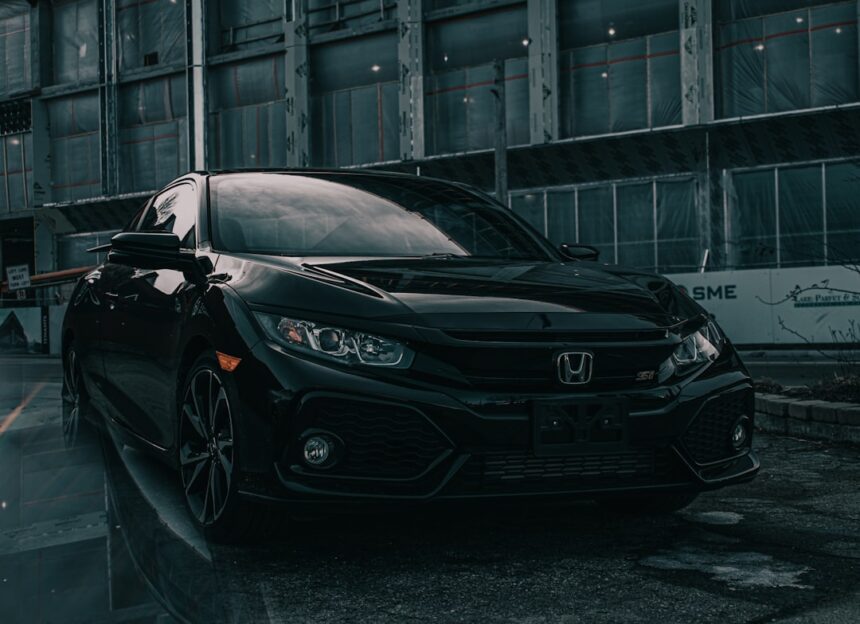 A black Honda Civic Si parked in front of a building under construction