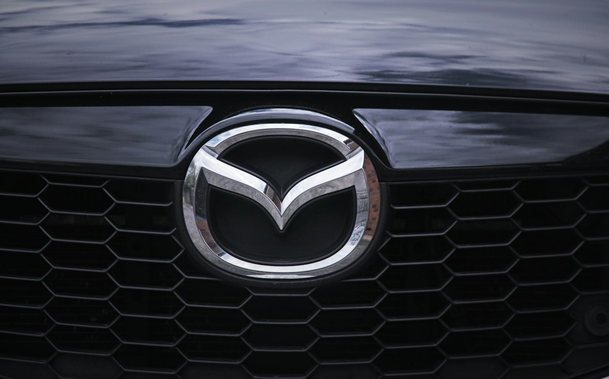 Close-up of a Mazda front grille and badge on black paintwork