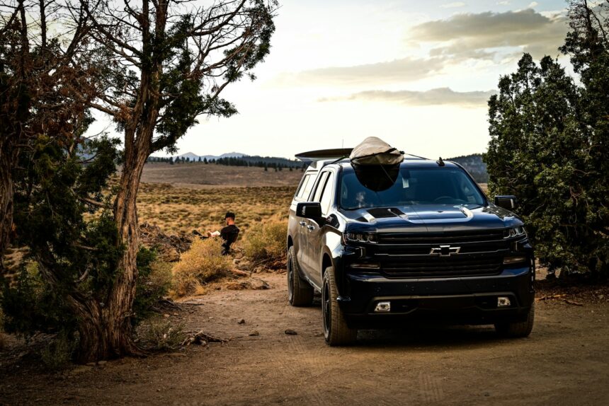Black Chevrolet Silverado pickup loaded for an outdoor trip
