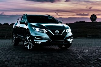 Blue Nissan Rogue crossover photographed at sunset